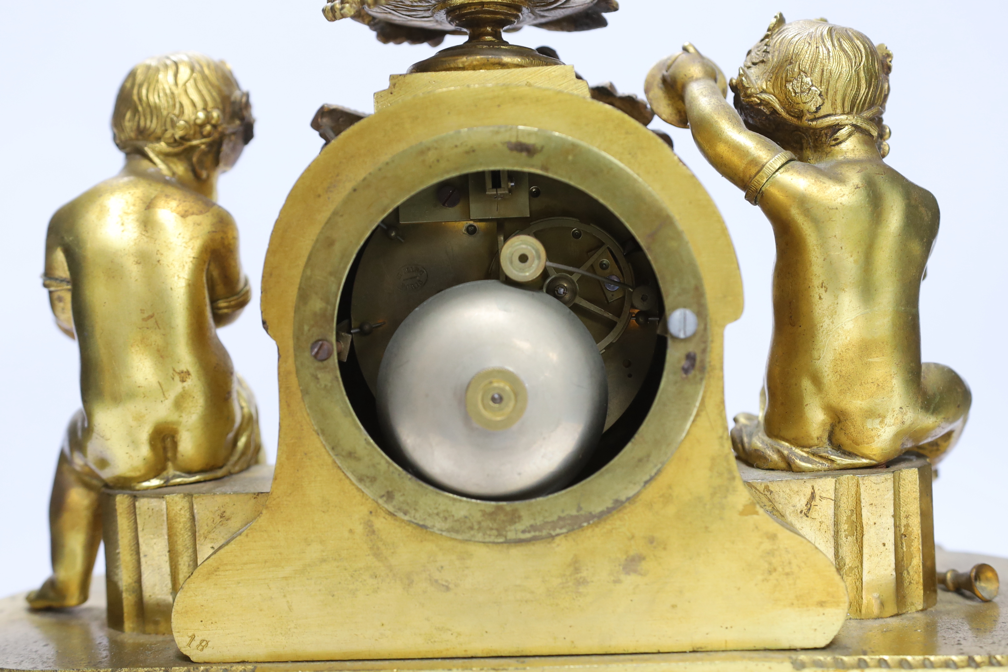 A late 19th century French ormolu mantel clock surmounted with cherubs, 31cm